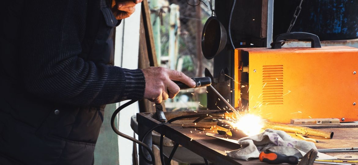 Man welding old shovel, close up.